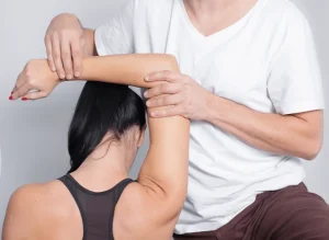 Fizjoterapeuta wyjaśniający pacjentowi ćwiczenia rehabilitacyjne" – Obraz przedstawiający fizjoterapeutę komunikującego się z pacjentem, co podkreśla znaczenie umiejętności komunikacyjnych w pracy fizjoterapeuty. Cechy dobrego fizjoterapeuty