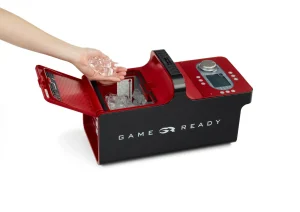 Ręka wkładająca kostki lodu do pojemnika chłodzącego urządzenia Game Ready.