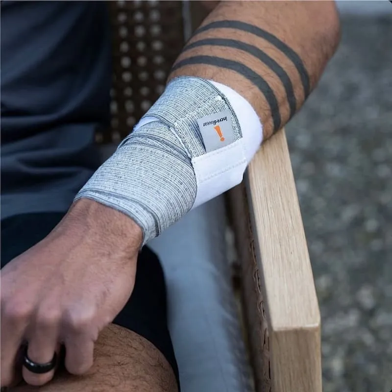 Mężczyzna z tatuażem nosi taśmę Incrediwear na nadgarstku
