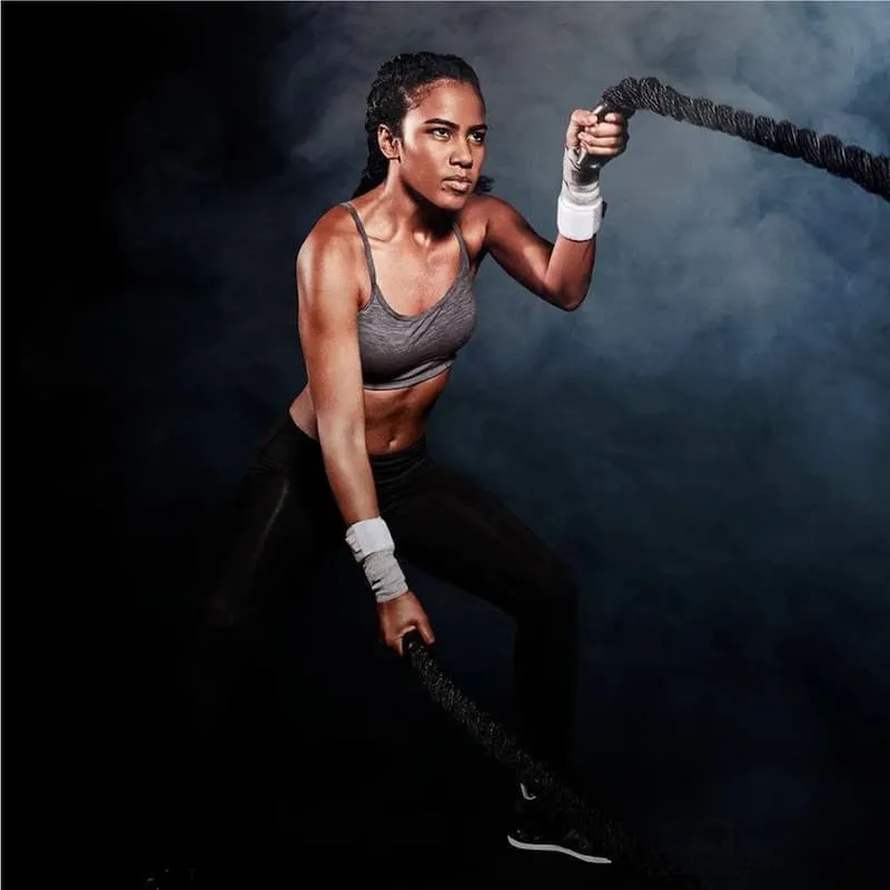 Kobieta trenująca z linami, nosi taśmy Incrediwear na nadgarstkach